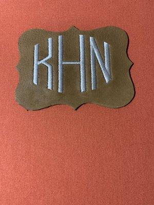 A piece of cowhide that was embroidered with initials.