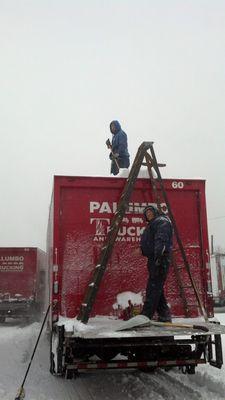 Matt and Luis cleaning off the trucks after a winter storm.