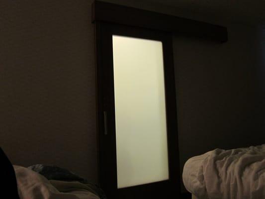 Because of the frosted glass sliding door, leaving the light on in the bathroom makes the whole room glow at night!