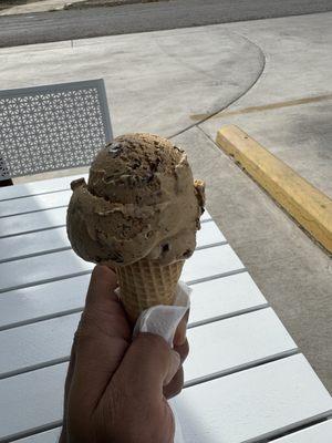 Coffee ice cream in a sugar cone.