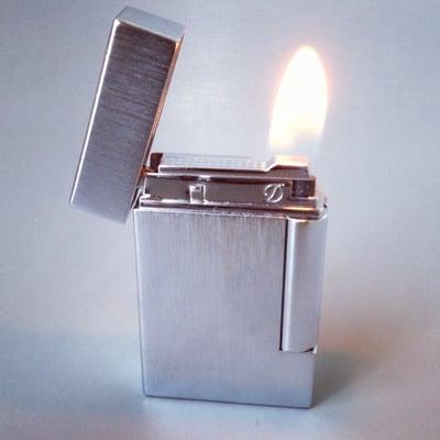 The soft yellow flame of an S.T. Dupont Ligne 8 lighter.