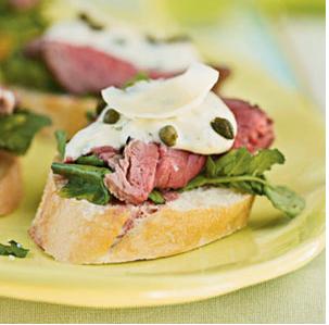 Sliced tenderloin atop a baguette slice with arugula, citrus aioli, capers, and a parmesan shaving.