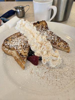 Stuffed French toast with fresh blueberries and strawberries with powdered sugar, cinnamon and whip cream.