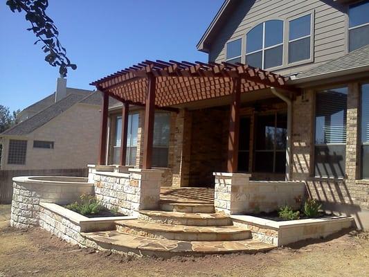 outdoor living space: limestone walls ,oklahoma patio, cedar pergola and flower beds