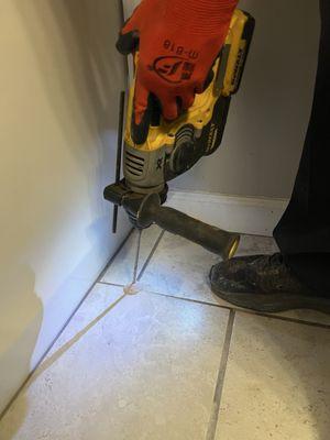 Drilling between the grout lines to inject termite poison. See after photo.