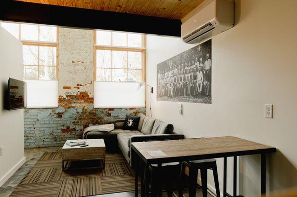 Lower level living room area of one of our Rooms with a couch and TV and eating area