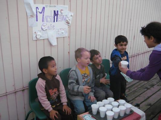 Preschoolers selling goods to the older children.