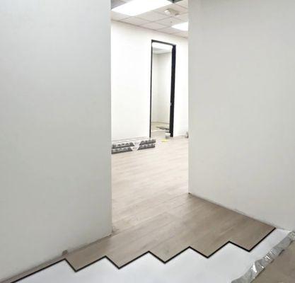 Installing LVP flooring in commercial office space.
