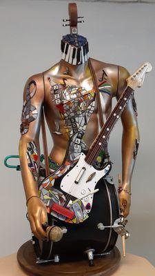 Rotating glass/mixed media one-man-band.