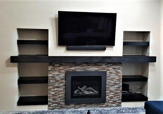 completed fireplace with full length mantel and floating shelves