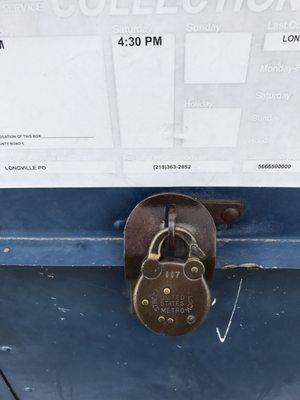Old school lock on the USPS drop box out side the office