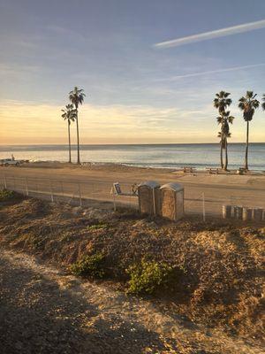 View from a train passes coastal parks, pullouts, and public areas, some with surfing.