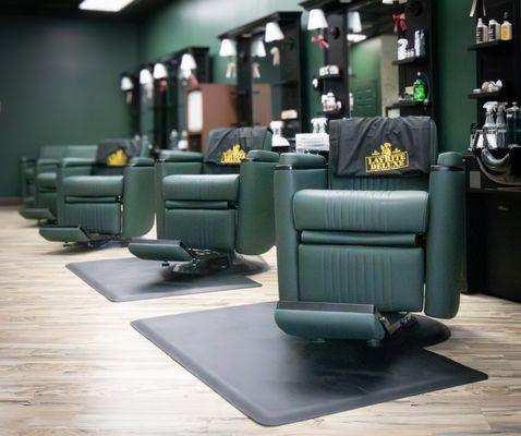 A line of deluxe chairs ready for the next round of cuts. Each station prepped for precision, and comfort.