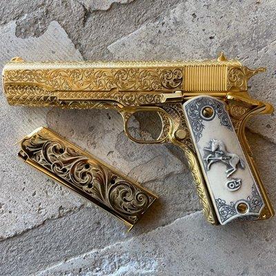 Colt 1911 Government model .45 ACP with full coverage scrollwork in 24k and faux ivory carved grips.