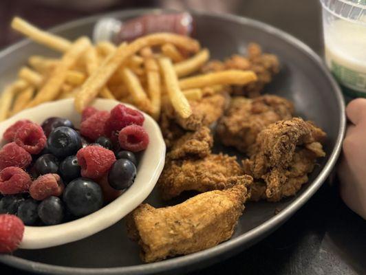 Children's chicken nugs with fries and fresh fruit.