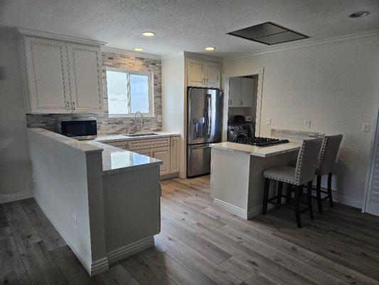 Overall Kitchen with range hood installed in the ceiling. This is operated with remote control.