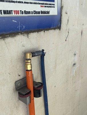 Worn out and ripped hose spraying pink soap all over any unlucky customer. Signs of wear and tear are very old.