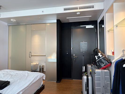 Bedroom/bathroom with a broken glass door.