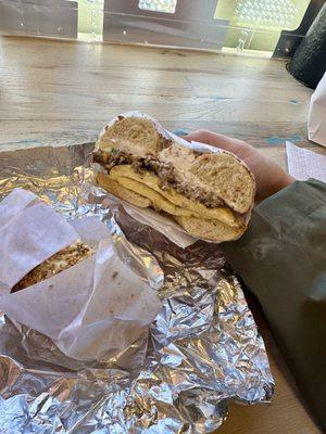 Steak, egg, & cheese on an onion bagel with scallion cream cheese.