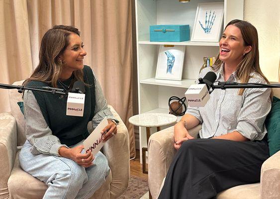 Two women recording in our podcast studio, laughing