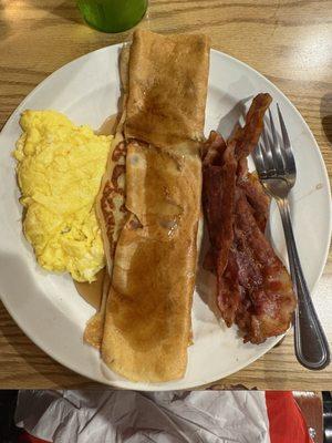 Scrambled eggs, Swedish pancakes with syrup and crispy perfect bacon