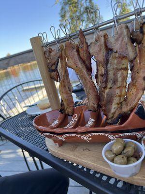 Hanging pork belly that is lit like a pu pu platter
