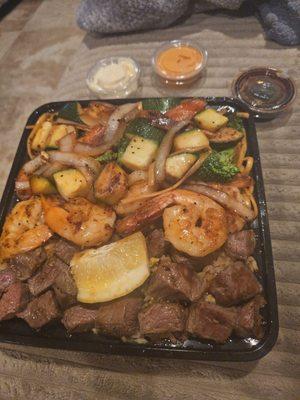 Steak shrimp veggies and noodles and rice
