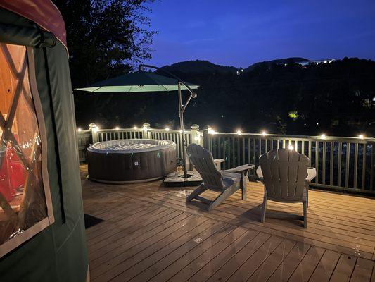 Night view with decorative lighting of Hot tub on deck with mountain view at The Stekoa Yurt glamping site