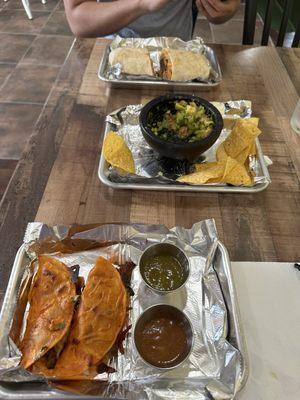 Birria tacos (bottom), guacamole (middle), Coca Cola carnitas burrito (top)