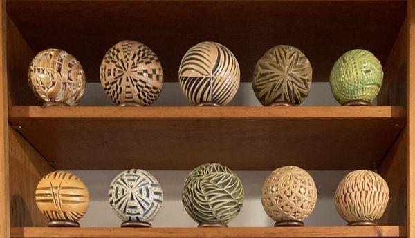 These are hollow carved spheres made from clay. Each piece is hand made and carved by me. Check my video on You Tube for a demonstration.