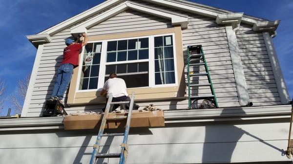 The guys hard at work on a three light double hung window with new smart trim all around.With moisture barrier tape and header flashing A+
