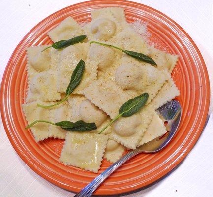 Pumpkin Ravioli Homemade Roasted Squash Ravioli's dressed with sage butter sauce, and garnished lightly with Perocino Cheese