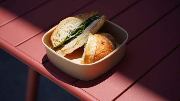 Croissant Sammy. Ham, cheese, romaine, onions, cilantro, mustard, thousand island sauce.