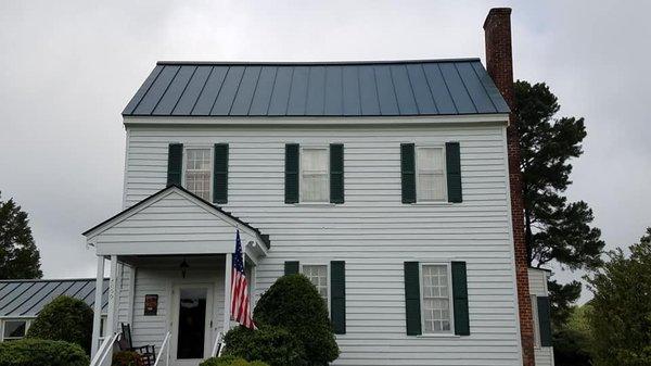 Standing Seam Metal Roof with Capped Ridge on Farmhouse