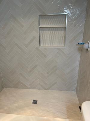 Specialized herringbone tile installation for a unique and timeless shower design. Ideal for upscale bathroom renovations.