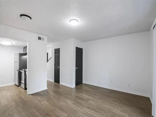 A room with a black door and a white wall.