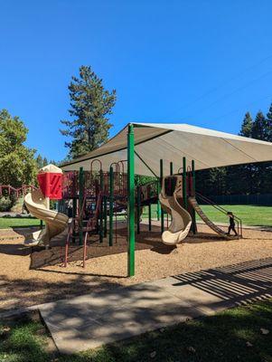 Shade structure and individual restrooms for male and female. Parking in the paved parking lot and in the dirt adjacent to the road.