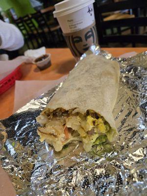 Breakfast burrito with sausage, egg, potatoes, green salsa, cilantro guacamole, Pico de gallo, sour cream.