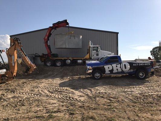 Installing a commercial aerobic system in an industrial park, the crane truck is setting the 2000gallon tank off in hole