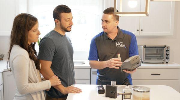 Owner of HQ Water Solutions explaining water test results to a customer.