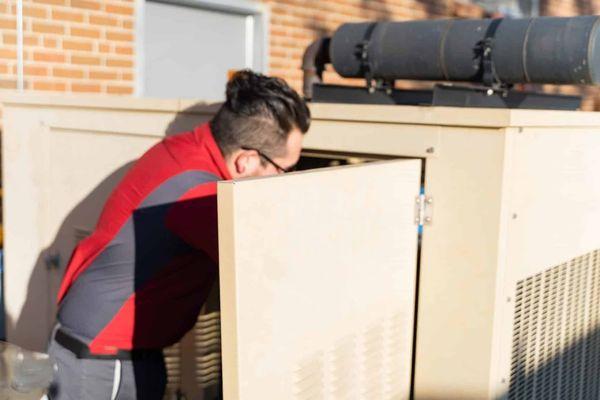 tech fixing a generator