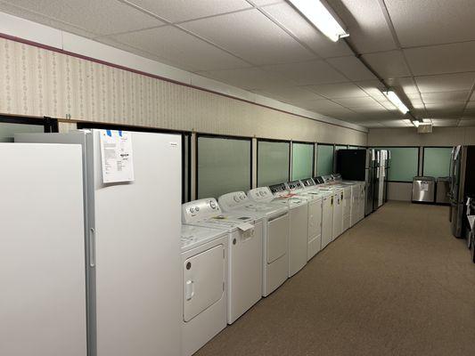 A showroom section featuring an extensive selection of top-loading and front-loading washers and dryers.