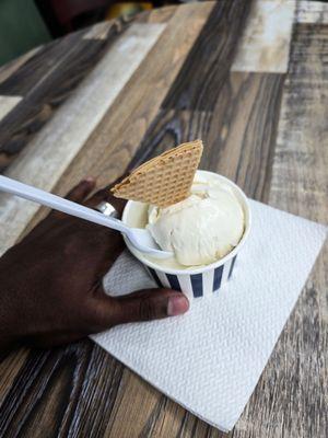 One scoop of Vanilla Ice cream in a cup with waffle cone topping