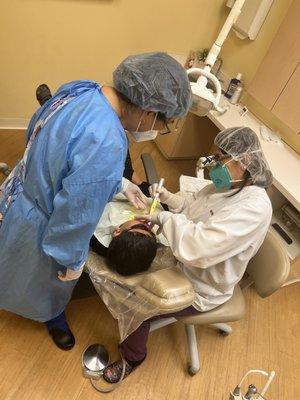 Putting sealant in my sons teeth.
