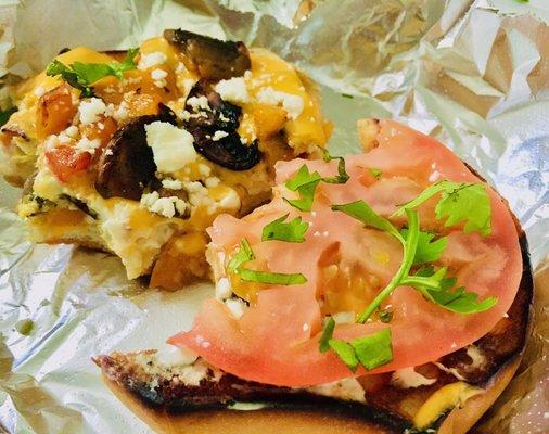 Veggie breakfast sandwich with sautéed mushrooms and peppers and tomato and cream cheese served open face on a toasted bagel
