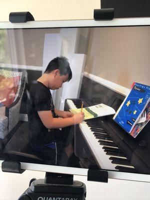 Student during online lesson, doing his theory work.