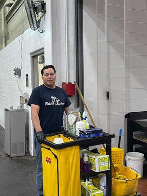 janitor with janitorial cart at industrial facility