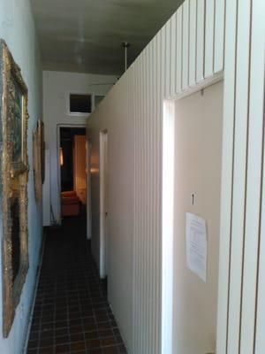 Hallway, divided into 3 different rooms. Walls don't go up all the way, so don't expect privacy