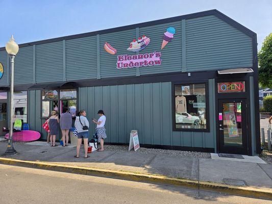 Northwest corner of the ice cream shop and covered walk-up window, and entrance to interior.
