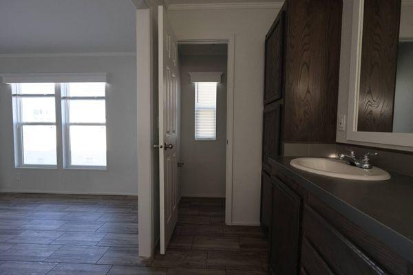 an empty bathroom with a sink and a door to a hallway